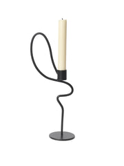 Black candle holder with a white candle on a white background
