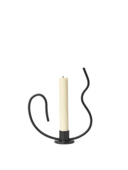 Black candle holder with a white candle on a white background