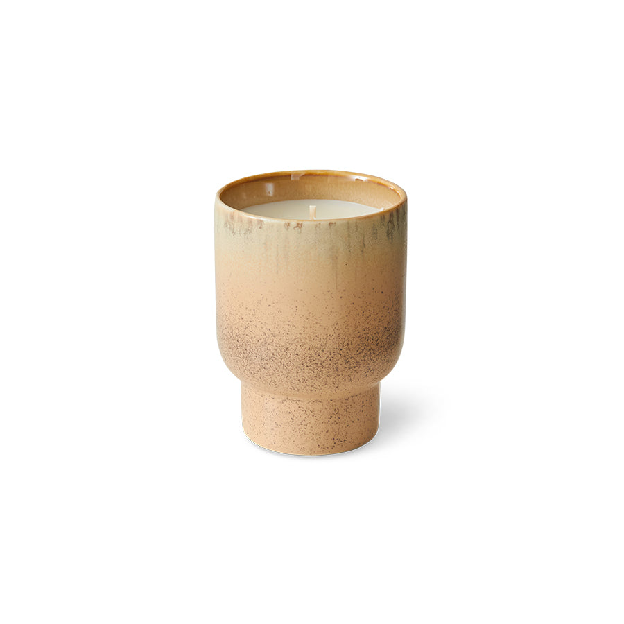Beige ceramic candle with speckled texture on a white background