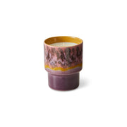 Ceramic candle with a pink and yellow design on a white background