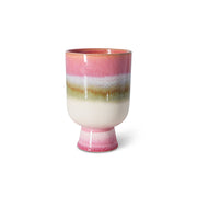 Ceramic plant pot with multicolored stripes on a white background