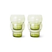 Two green glass tumblers on a white background