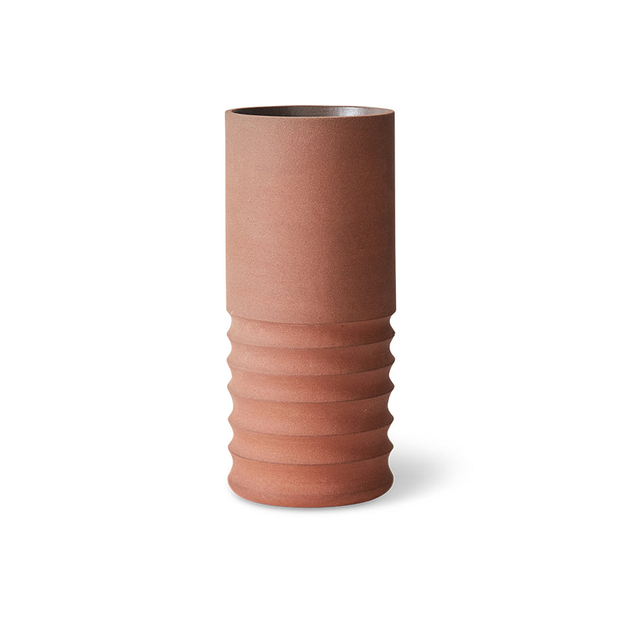 Terracotta-colored vase with ribbed texture on a white background