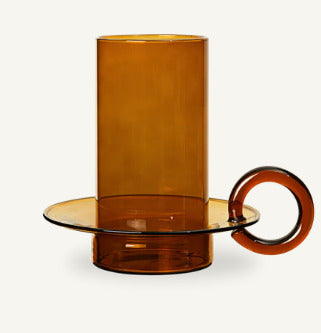 Amber-colored glass holder with a cylindrical container on a white background