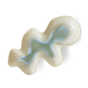 Wavy ceramic plate with a textured surface on a white background