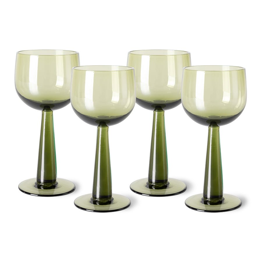 Set of four green wine glasses on a white background